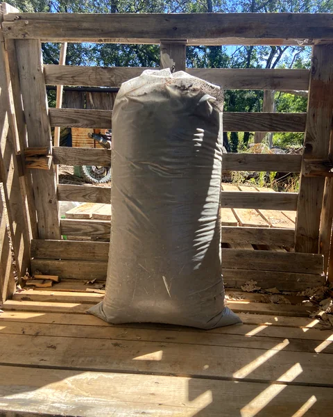 Sac de fumier de Migon sous l'abri de l'atelier à Murles, vu en plan large
